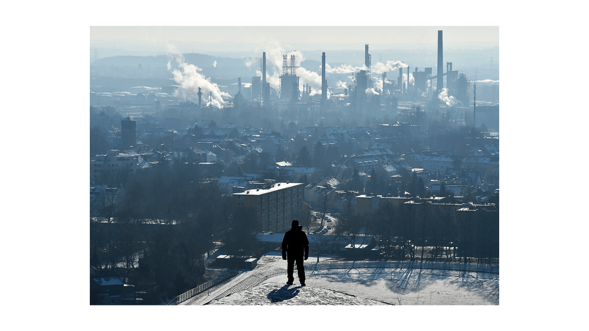 Man looks at refinery in distance